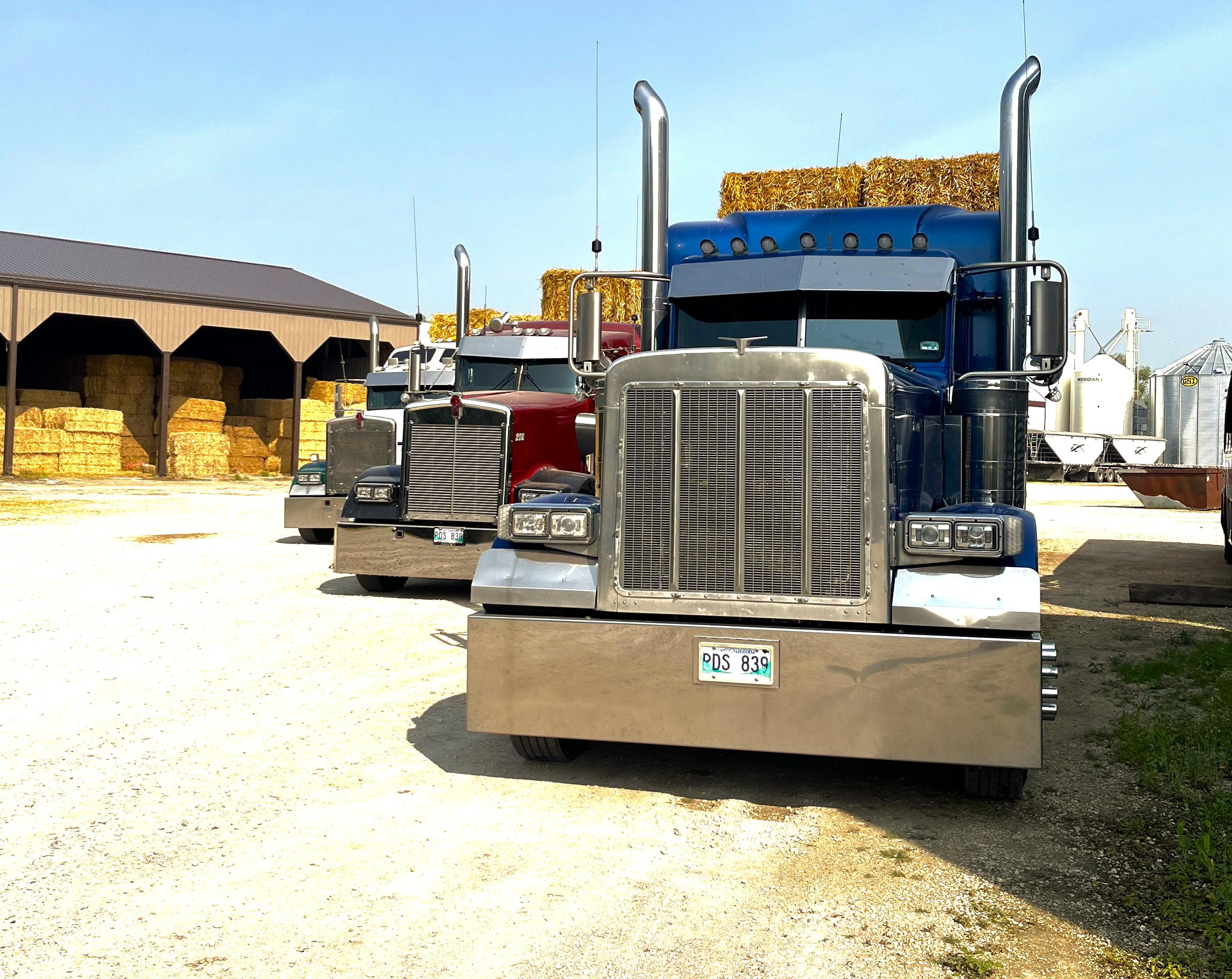 River Trails Transport fleet parked at the yard with hay storage in the background