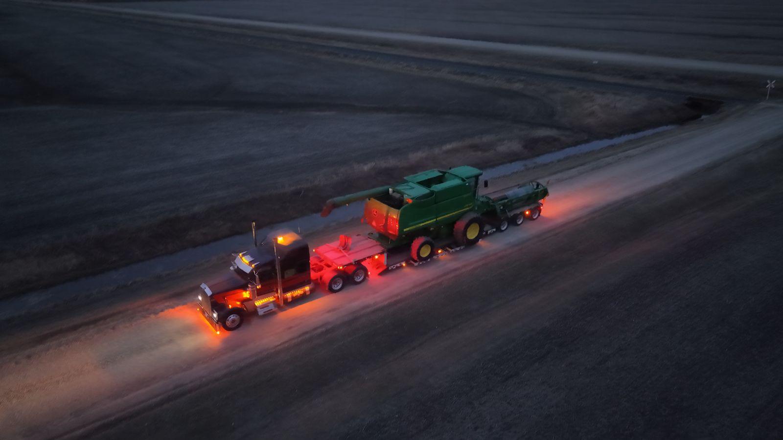 Combine loaded on the RGN double drop photographed by drone at night