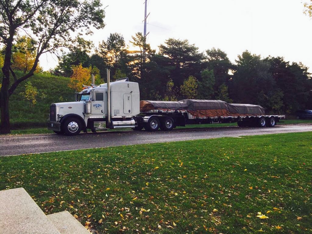 Loaded step-deck trailer rolling out of the yard