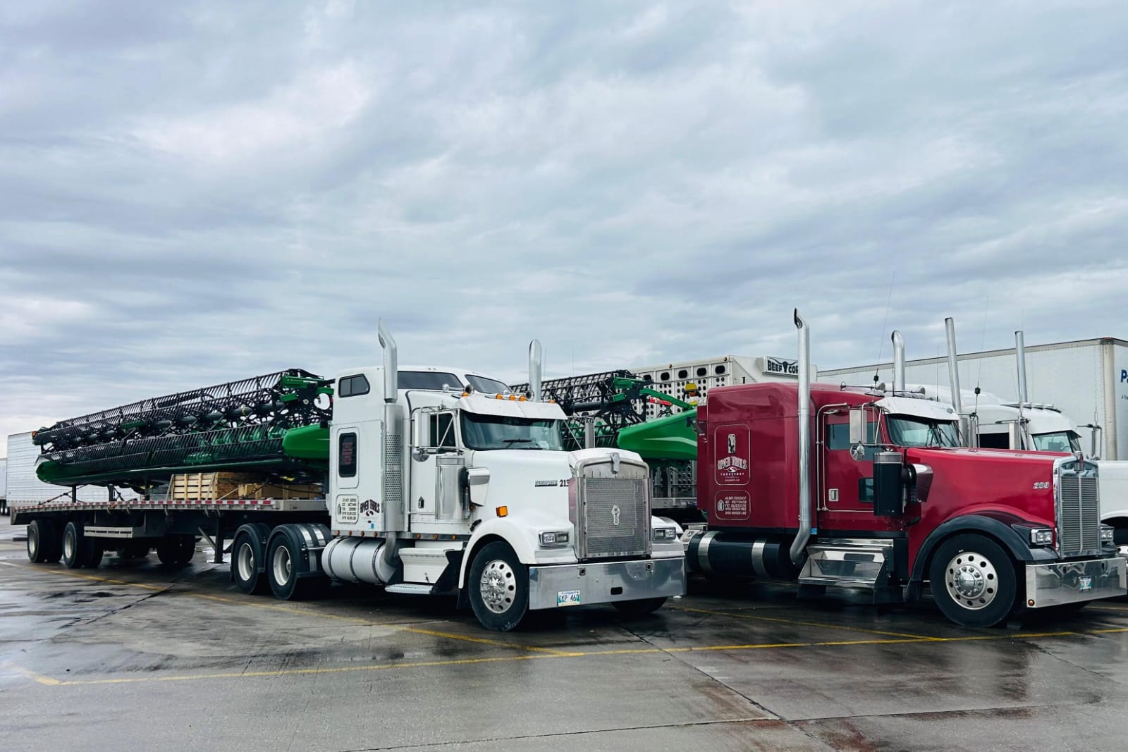 River Trails Transport Kenworths with loaded flat decks parked at the yard