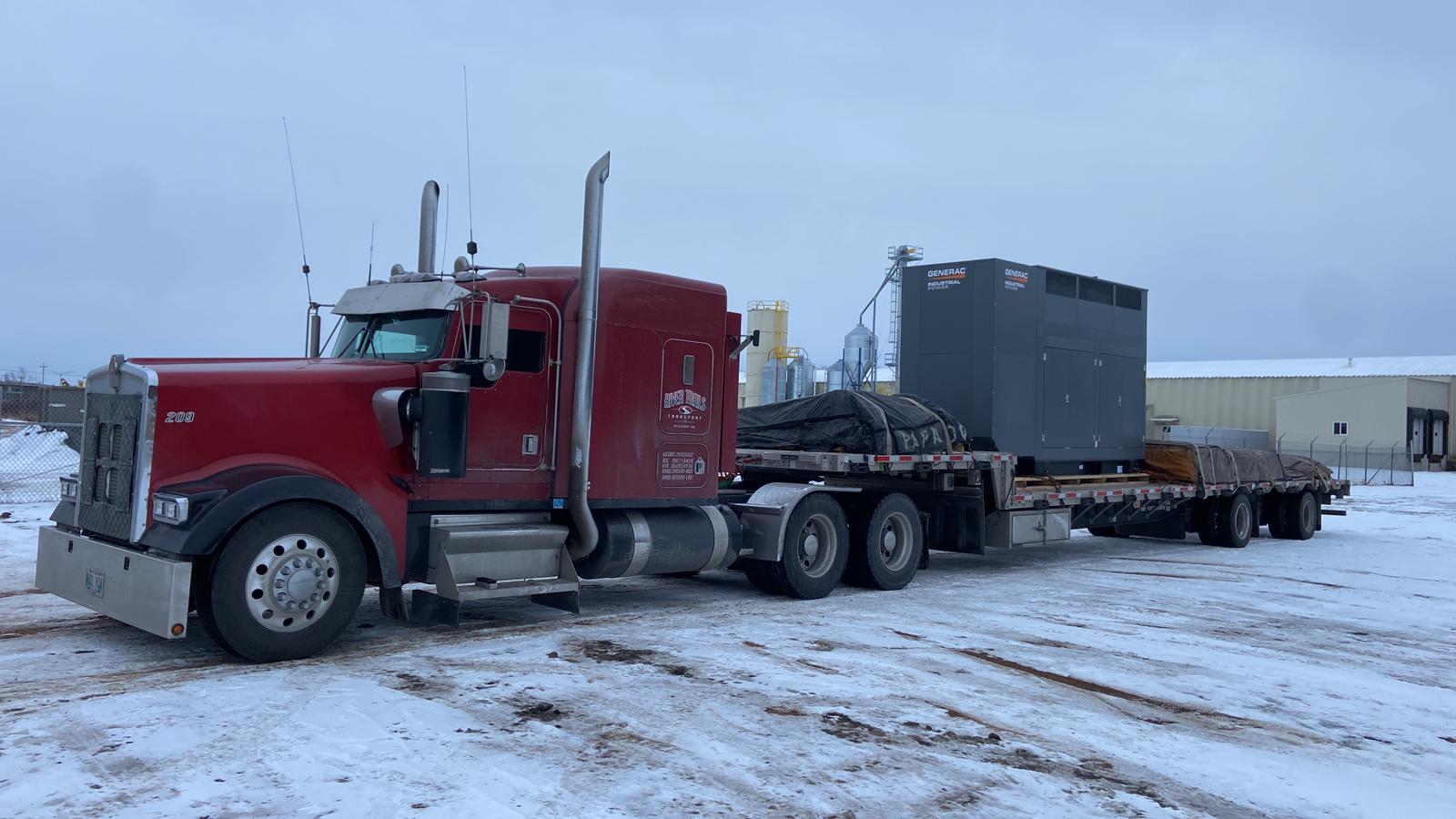 Industrial equipment loaded on a River Trails Transport tandem step deck