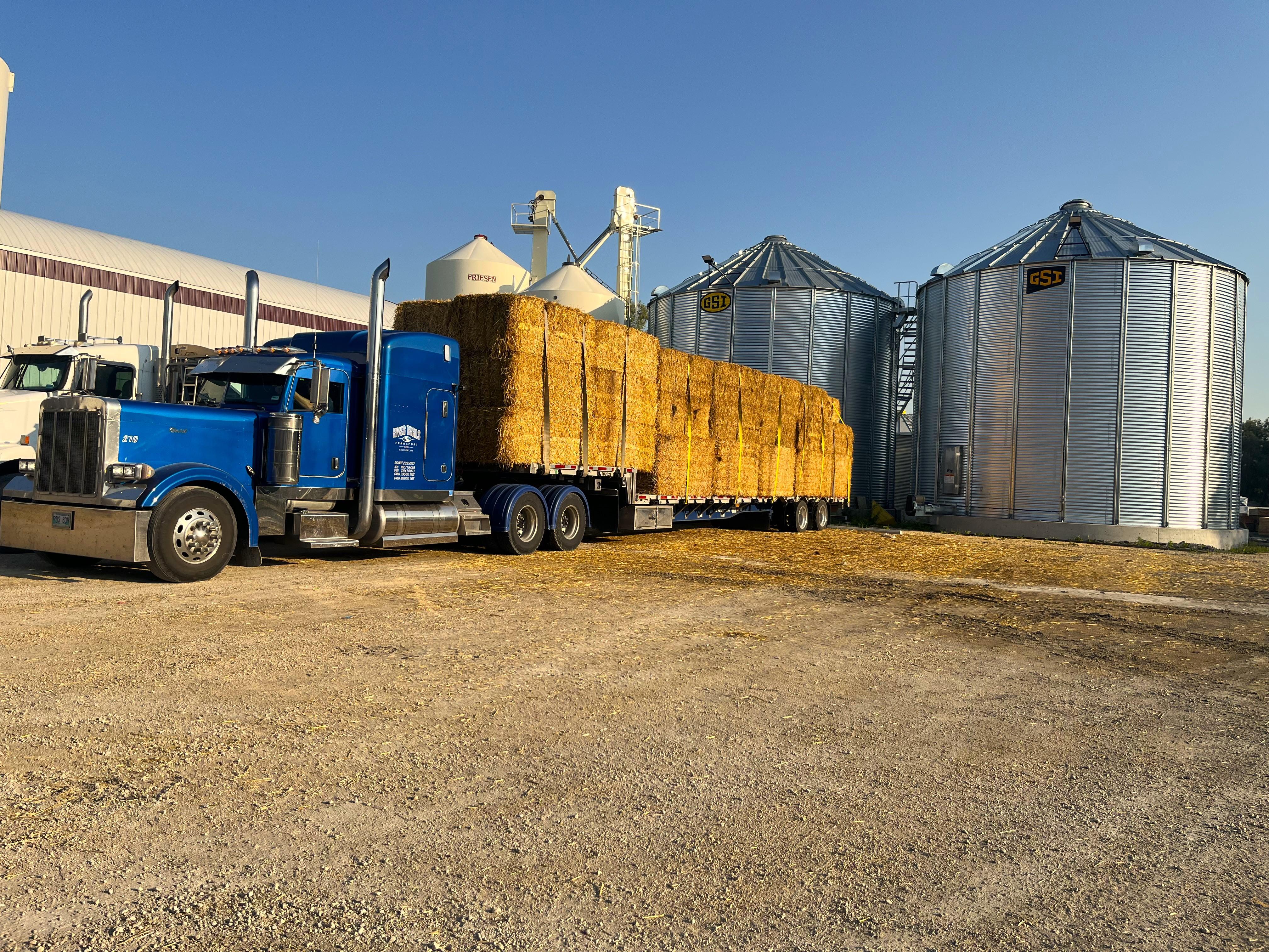 Straw load on a River Trails Transport tandem step deck at the yard